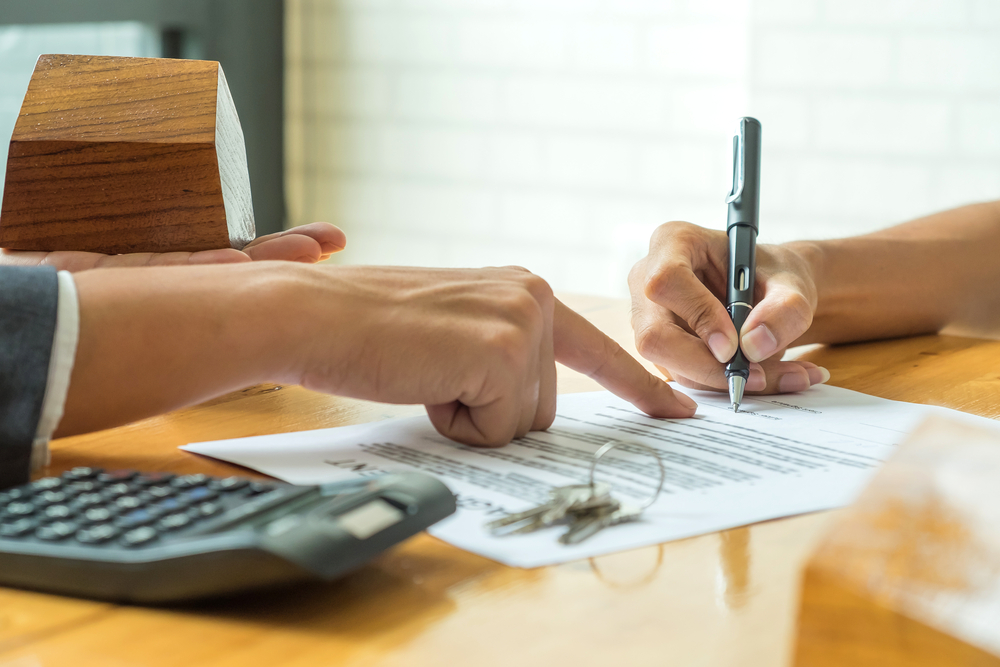 buyers are signing a home purchase agreement from a broker