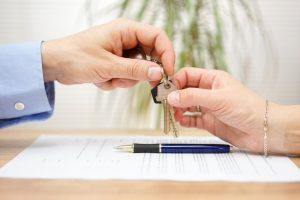 real estate agent gives house keys to his client after signing contract